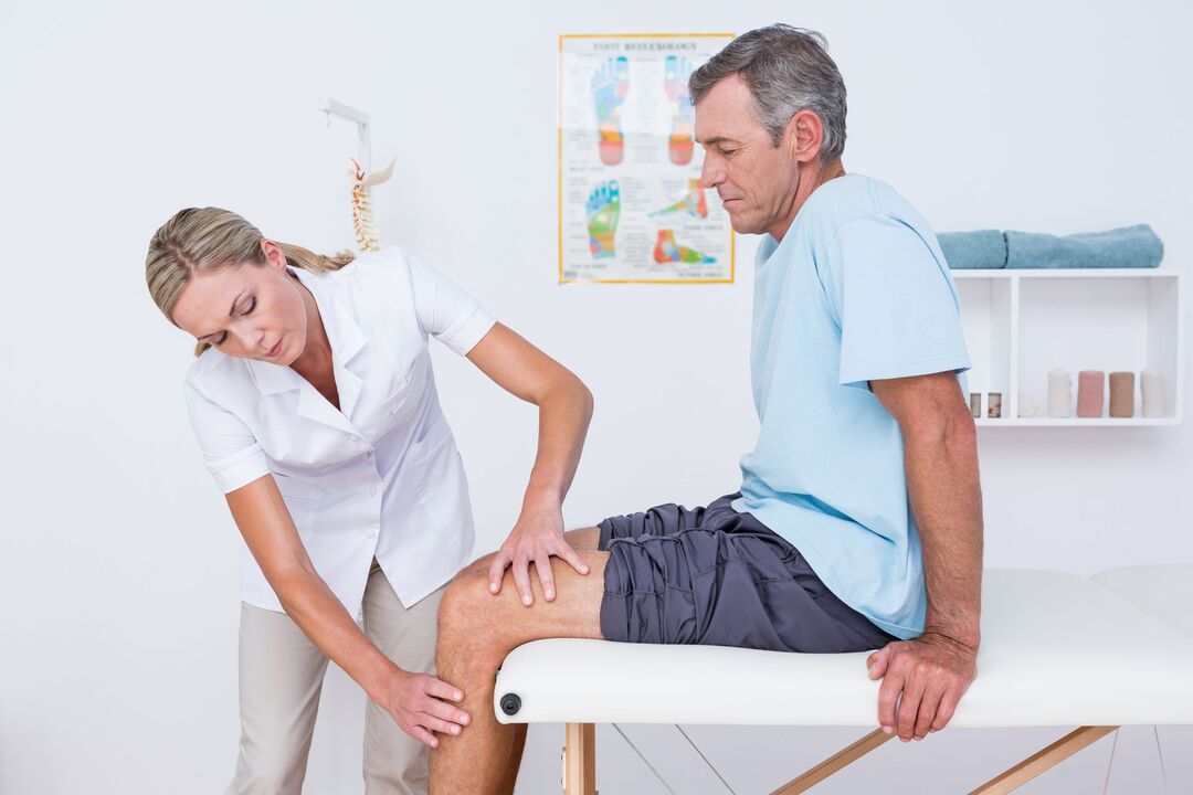 lekarz badający pacjenta z artrozą kolana
